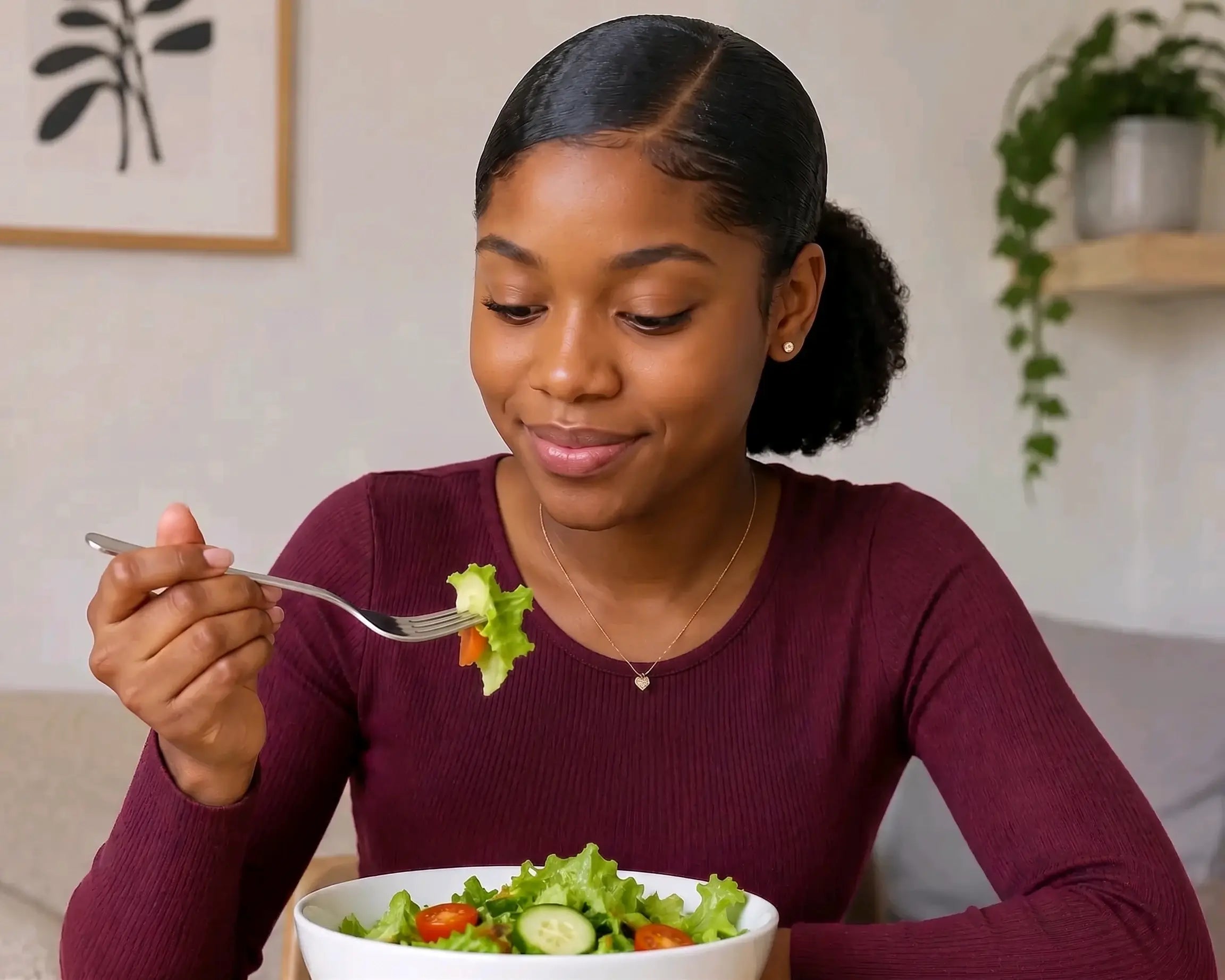 Jeune femme mangeant une salade composée de laitue, concombre et tomates cerises, illustrant une alimentation saine, équilibrée et riche en légumes frais.