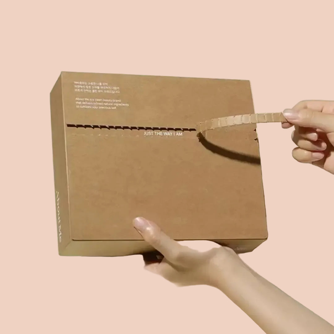 Mains ouvrant une boîte d'expédition e-commerce en carton kraft à l'aide d'une bande d'arrachage facile