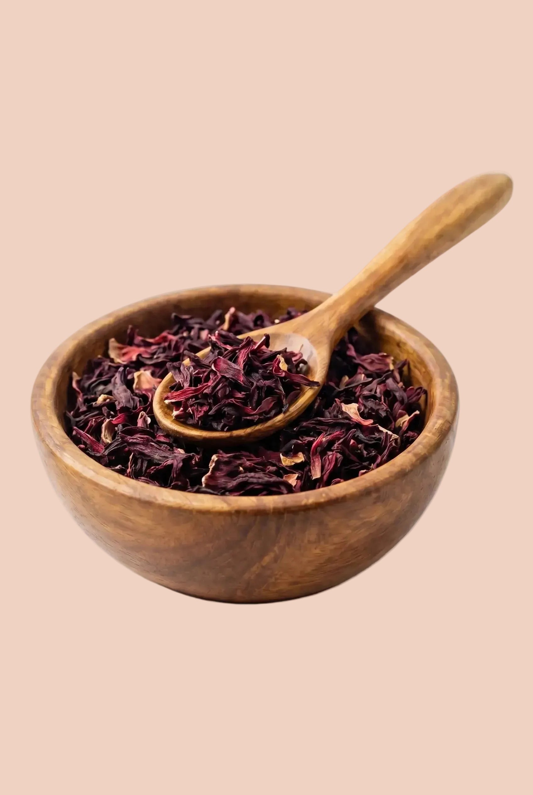 Fleurs d'hibiscus séchées bio dans un bol en bois avec une cuillère, idéales pour la préparation de l'infusion bissap.